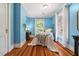 Bright bedroom with blue walls, hardwood floors, desk, and natural light from large windows at 210 Peachtree St, Roxboro, NC 27573