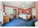 Bright bedroom showcases red wallpaper and a doorway leading to the bathroom at 210 Peachtree St, Roxboro, NC 27573