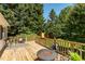 Outdoor deck with wood flooring, a cozy fire pit with stone surround, and seating area for relaxing at 210 Peachtree St, Roxboro, NC 27573