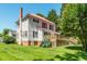 Charming two-story home with a red roof, black shutters, and a beautifully landscaped backyard at 210 Peachtree St, Roxboro, NC 27573