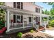 Inviting white front porch with classic columns, comfortable seating, and a charming, welcoming atmosphere at 210 Peachtree St, Roxboro, NC 27573