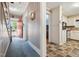 Inviting hallway features wallpaper and opens to a kitchen with white cabinets at 210 Peachtree St, Roxboro, NC 27573