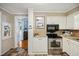 Bright kitchen with white cabinetry and modern stainless steel appliances at 210 Peachtree St, Roxboro, NC 27573