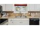 Cozy kitchen features granite countertops, a stainless steel sink and white cabinets at 210 Peachtree St, Roxboro, NC 27573