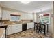 Functional eat-in kitchen with black appliances, tile floor, and bright windows at 210 Peachtree St, Roxboro, NC 27573