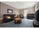 Living room with large leather sofa, piano, fireplace and vintage wall decor at 210 Peachtree St, Roxboro, NC 27573