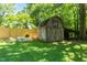 Backyard shed surrounded by lush greenery, offering extra storage and a charming outdoor space at 210 Peachtree St, Roxboro, NC 27573