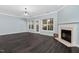 Bright living room with dark floors, fireplace, multiple windows, and a glass door to the backyard at 2106 White Pond Ct, Apex, NC 27523