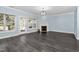 Bright living room with dark floors, fireplace, multiple windows, and a glass door to the backyard at 2106 White Pond Ct, Apex, NC 27523