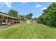Expansive backyard with a covered patio, fire pit, storage shed, and lush greenery, perfect for outdoor activities at 2119 Northcrest Dr, Elon, NC 27244