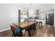 Open dining area leading to kitchen; wooden table, black chairs, modern light fixture at 2119 Northcrest Dr, Elon, NC 27244