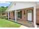 Close-up of brick home's inviting front porch with seating and a wreath at 2119 Northcrest Dr, Elon, NC 27244