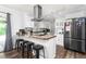 Bright kitchen with stainless steel appliances, island with bar stools, and modern track lighting at 2119 Northcrest Dr, Elon, NC 27244