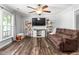 Comfortable living room with hardwood floors, TV, ceiling fan, and shelving at 2119 Northcrest Dr, Elon, NC 27244