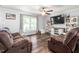 Living room with hardwood floors, neutral walls, ceiling fan, and comfortable couches at 2119 Northcrest Dr, Elon, NC 27244