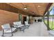 Relaxing covered patio featuring a comfortable seating area, ceiling fans, and a rustic wood ceiling at 2119 Northcrest Dr, Elon, NC 27244