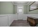 Inviting entryway with light green walls, white wainscoting, wood floors, and decorative accents at 22 Combine Trl, Benson, NC 27504