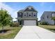 Charming two-story home featuring gray siding, stone accents, and a two-car garage with a concrete driveway at 22 Combine Trl, Benson, NC 27504