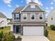 Charming two-story home featuring a stone-accented garage and welcoming front porch at 22 Combine Trl, Benson, NC 27504