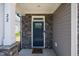 Stylish front entrance with a dark blue door, stone accents, and white columns showcasing modern design at 22 Combine Trl, Benson, NC 27504