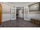 Versatile room with white wainscoting, gray wood floors, and decorative doors with a mirror at 22 Combine Trl, Benson, NC 27504