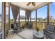 Inviting screened porch with wicker furniture, ceiling fan and views of the fenced backyard at 22 Combine Trl, Benson, NC 27504