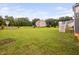 Large fenced backyard with lush green grass, play equipment, and mature trees surrounding the property at 265 Beckwith Ave, Clayton, NC 27527