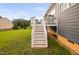 Exterior view of the rear deck with stairs leading to a spacious backyard area on a sunny day at 265 Beckwith Ave, Clayton, NC 27527