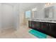 Bright bathroom featuring a dual sink vanity, a walk-in shower with tiled walls and floors at 265 Beckwith Ave, Clayton, NC 27527