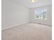 Bedroom features neutral carpeting, a window, and a view of the neighborhood at 265 Beckwith Ave, Clayton, NC 27527