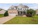 Charming two-story home featuring a brick-accented garage, covered porch, and manicured lawn at 265 Beckwith Ave, Clayton, NC 27527