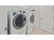 Bright laundry room with modern washer and dryer units, plus storage rack at 265 Beckwith Ave, Clayton, NC 27527