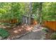 Lush, wooded backyard featuring mulch and gravel pathways, and mature trees at 28 Benchmark, Pittsboro, NC 27312