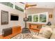 Cozy exercise room with ceiling fan, large windows, exercise bike, leather ottoman, and comfortable sofa at 28 Benchmark, Pittsboro, NC 27312