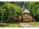 Beautiful exterior with wood stairs and landscaping, surrounded by mature trees, offering a serene setting at 28 Benchmark, Pittsboro, NC 27312