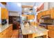 A kitchen featuring a large island with granite countertops, wood cabinets, and stainless steel appliances at 28 Benchmark, Pittsboro, NC 27312