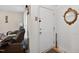 Entryway featuring a white door, gold framed mirror, and side view of a comfortable brown sofa at 308 E Gilbreath St, Graham, NC 27253