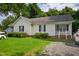 Charming home with gravel driveway and cozy front porch, enhanced by lush green lawn at 308 E Gilbreath St, Graham, NC 27253
