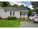 Inviting single-story home with a charming front porch and easy gravel driveway access at 308 E Gilbreath St, Graham, NC 27253