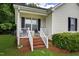 Charming front porch with brick stairs and white railing at 308 E Gilbreath St, Graham, NC 27253