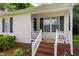 Welcoming front porch with classic railing detail and an inviting entry door and sidelight at 308 E Gilbreath St, Graham, NC 27253