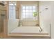 Elegant bathroom with a large soaking tub and a window that provides natural light at 308 Nashville Dr, Archer Lodge, NC 27527