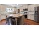 Modern kitchen features granite countertops, stainless steel appliances, island and hardwood floors at 308 Nashville Dr, Archer Lodge, NC 27527