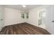 Inviting bedroom features wood floors, a ceiling fan, and view into a modern, adjoining bath at 313 13Th St, Butner, NC 27509