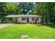 Inviting home featuring lush green lawn, established landscaping, and a welcoming entrance, perfect for families at 313 13Th St, Butner, NC 27509