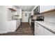 Modern kitchen with updated white cabinetry, granite countertops, stainless steel appliances, and luxury vinyl flooring at 313 13Th St, Butner, NC 27509