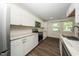 Kitchen features white cabinets, granite countertops, stainless appliances, and a view to the back yard at 313 13Th St, Butner, NC 27509