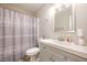 Bathroom with a shower and tub with a patterned curtain and gray vanity at 3622 Colchester St # 17, Durham, NC 27707