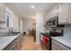 Traditional kitchen with stainless steel appliances and gray countertops; dining area visible at 3622 Colchester St # 17, Durham, NC 27707