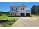 New two-story home showcasing a two-car garage under construction with an unfinished lawn and pleasant tree line at 3895 Josiah Ct, Nashville, NC 27856